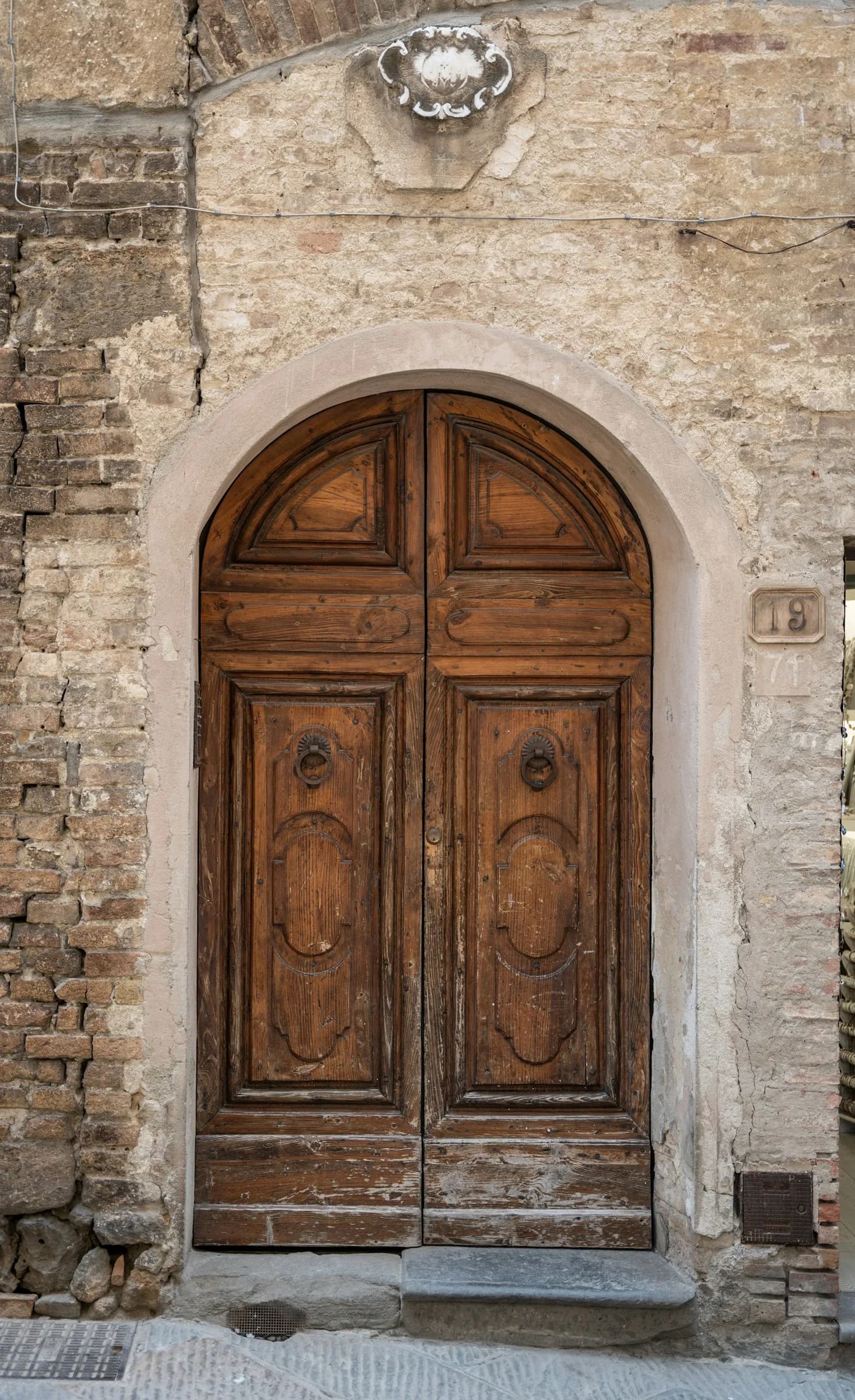 An arched wooden door in a stone frame