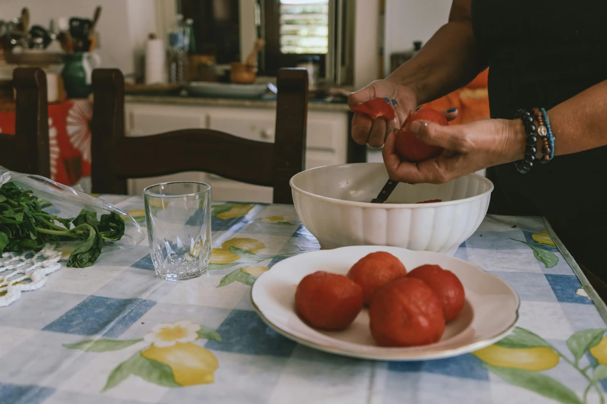 Pomodori e basilico su una tovaglia a quadri, pronti per il sugo