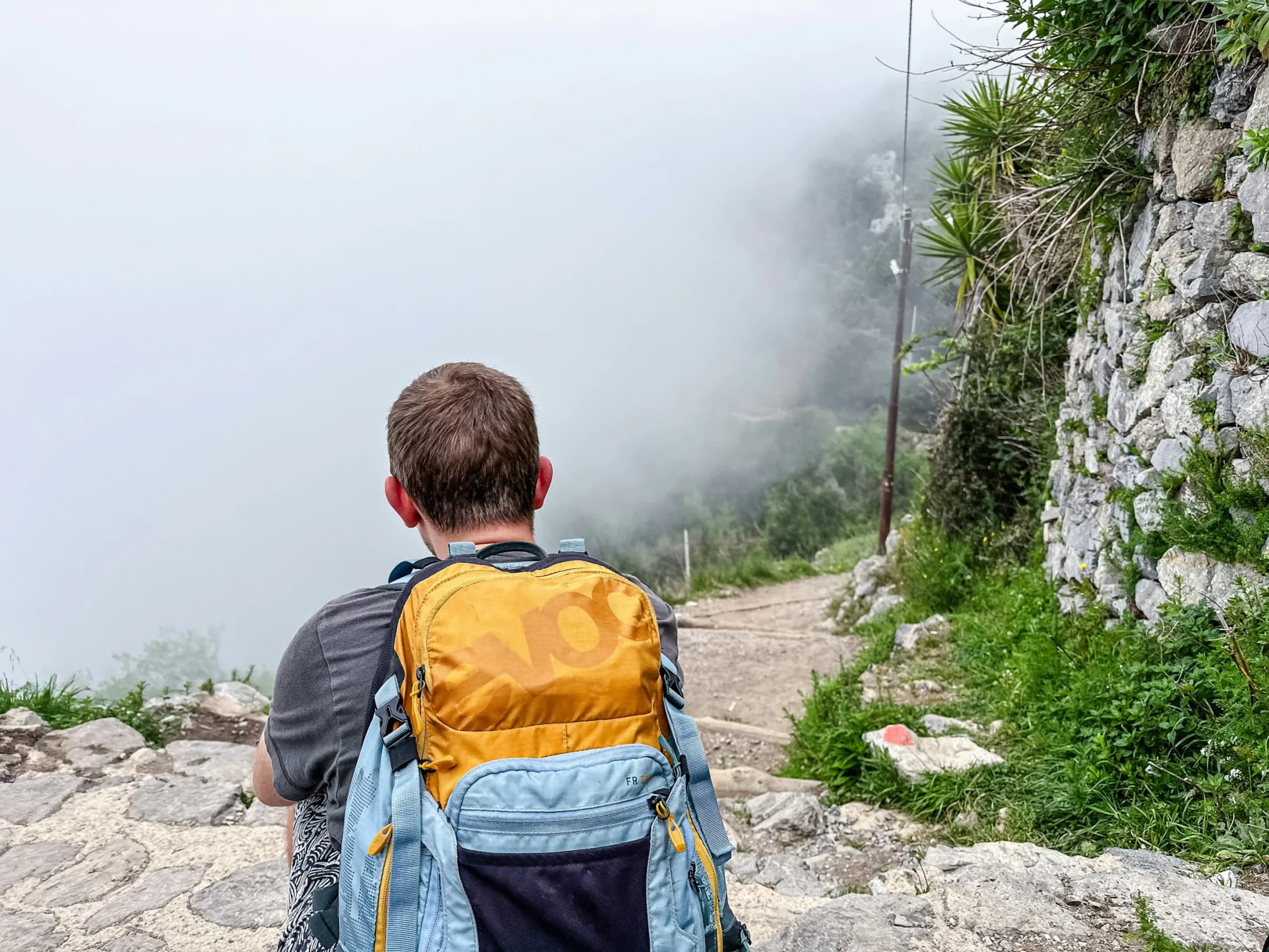 A walker on the Path of the Gods, mist rising from the sea