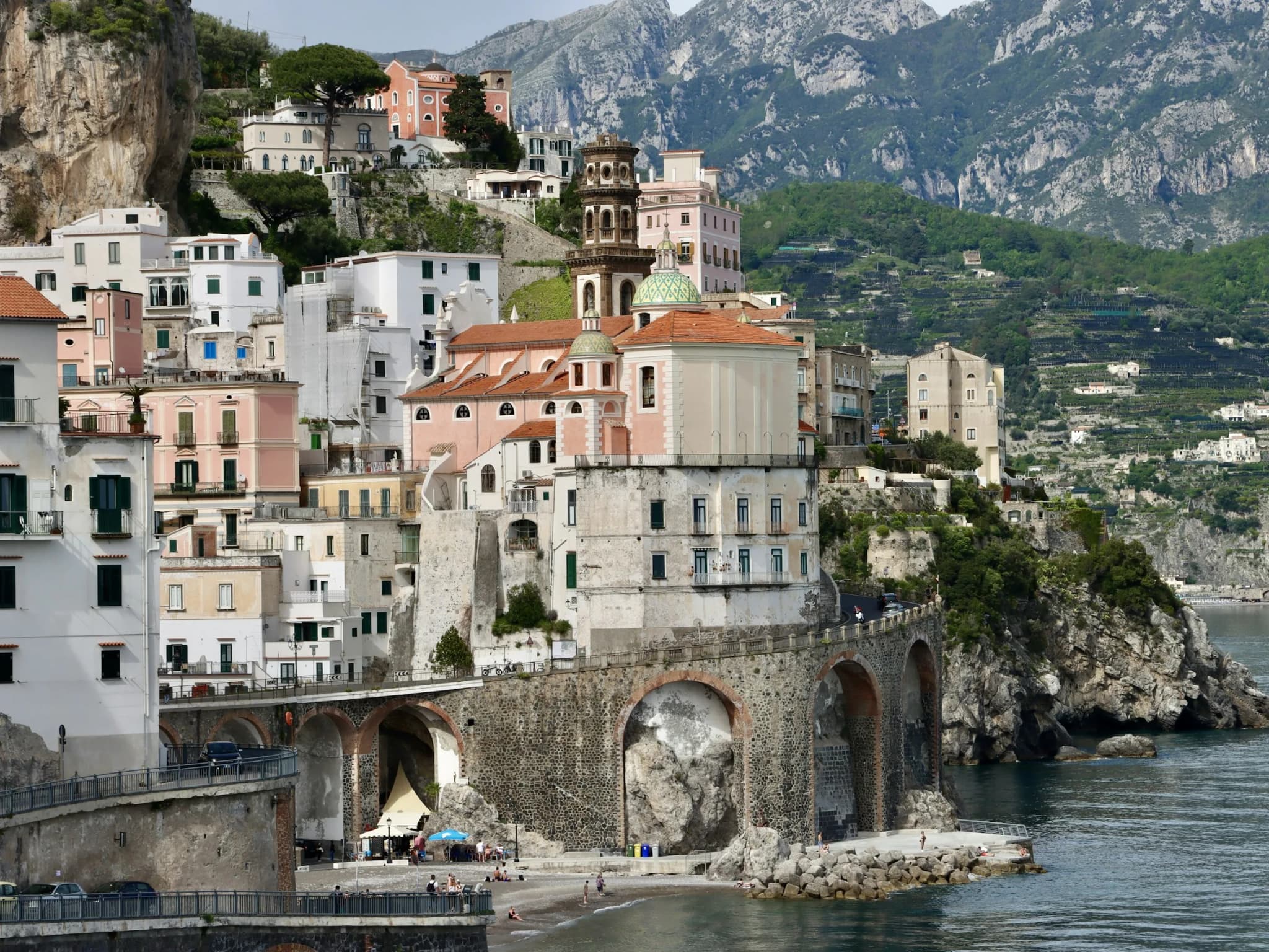 Atrani, white houses packed above the beach and the road on arches