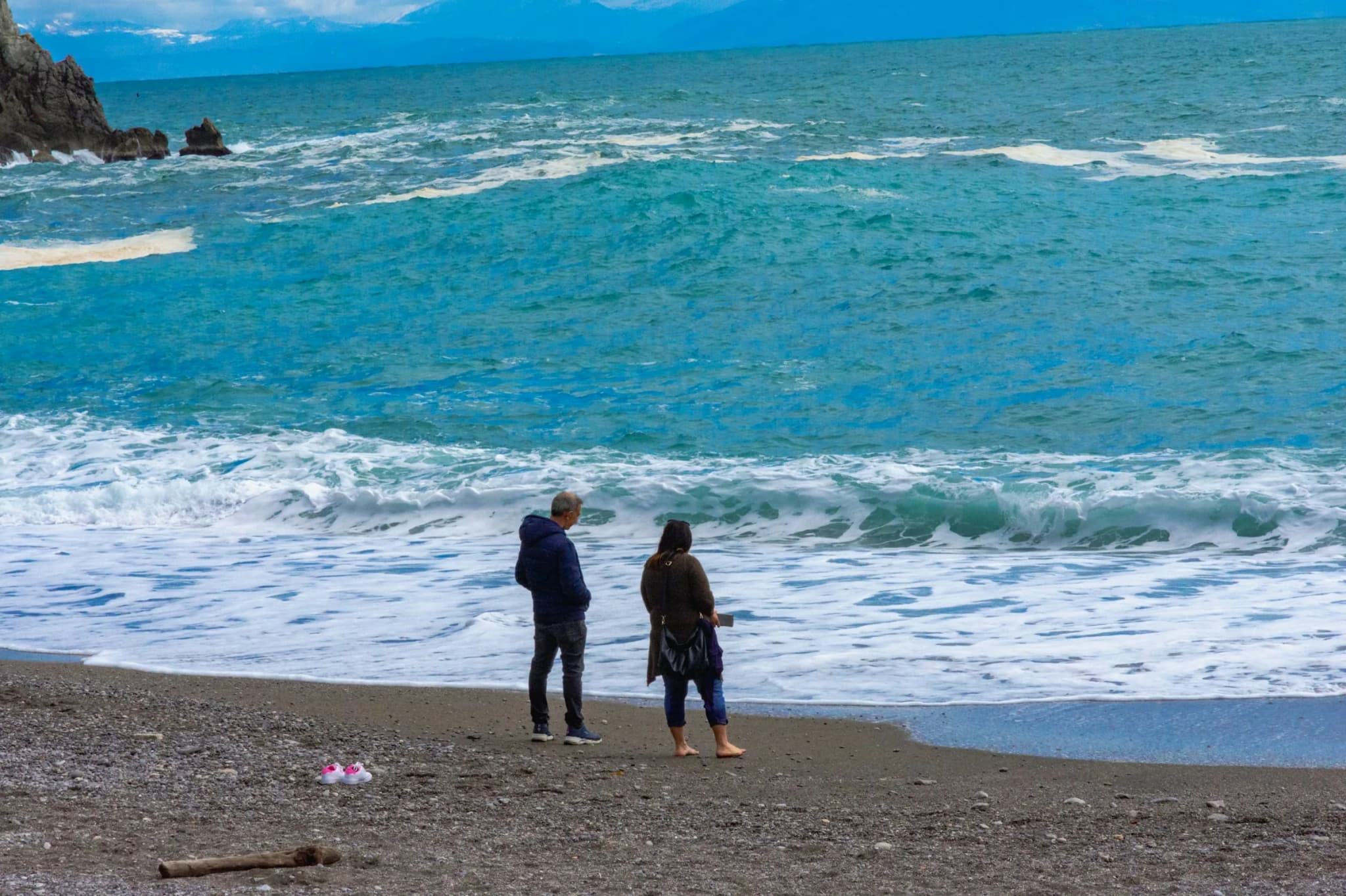 Due persone sulla riva davanti alle onde d’inverno